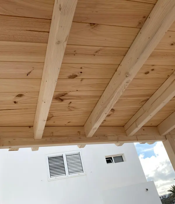 Techo revestido con madera y vigas vistas.