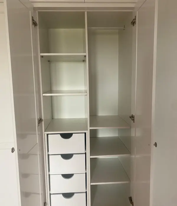 Vestidor blanco con módulos abiertos de almacenamiento.